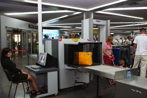 agent de sureté vérifiant les bagages à un portique d'aéroport