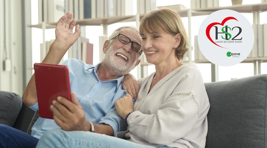 Seniors tenant une tablette tactile assis sur un canapé