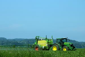 tractor spreading pesticides on a farm