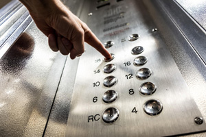 hombre pulsando los botones del ascensor