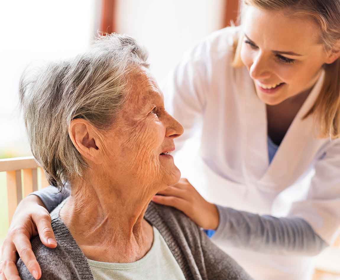 Une aide soignante en train d'aider une personne âgée