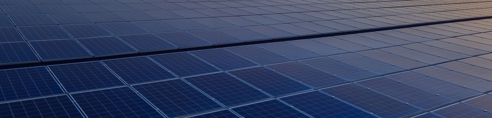 Panneaux solaires photovoltaïques bleus montés sur le toit d'un bâtiment pour produire de l'électricité propre et écologique au coucher du soleil. 