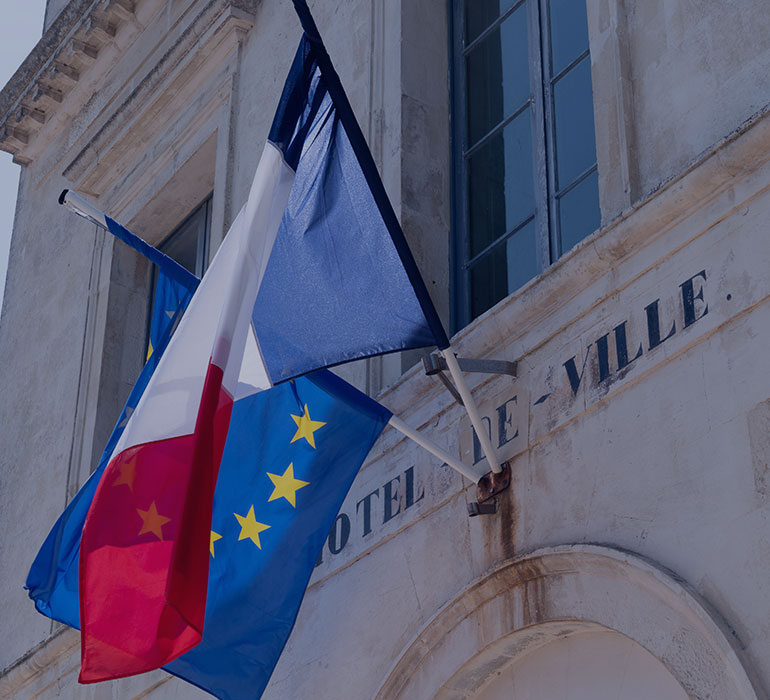 Un drapeau français et un drapeau européen sur le mur d'un hôtel de ville