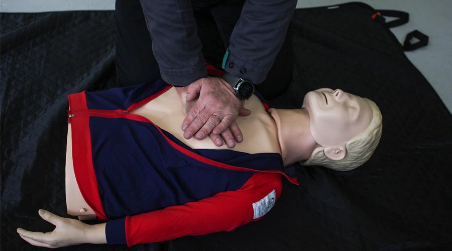 man performing first aid on a dummy