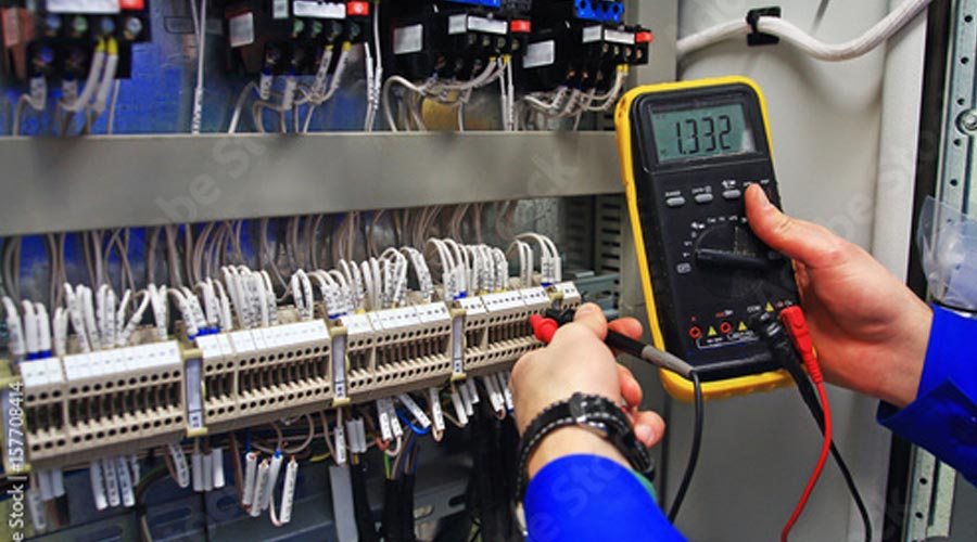 employee checking electrical measurements on an electrical panel