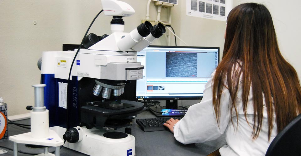 Dipendente di Apave che esegue test e misurazioni al microscopio
