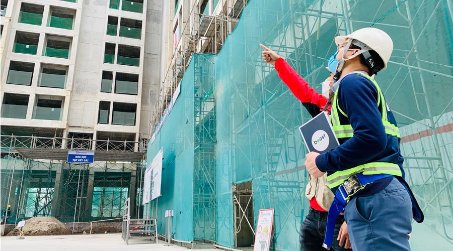 2 members of Apave team watching a building