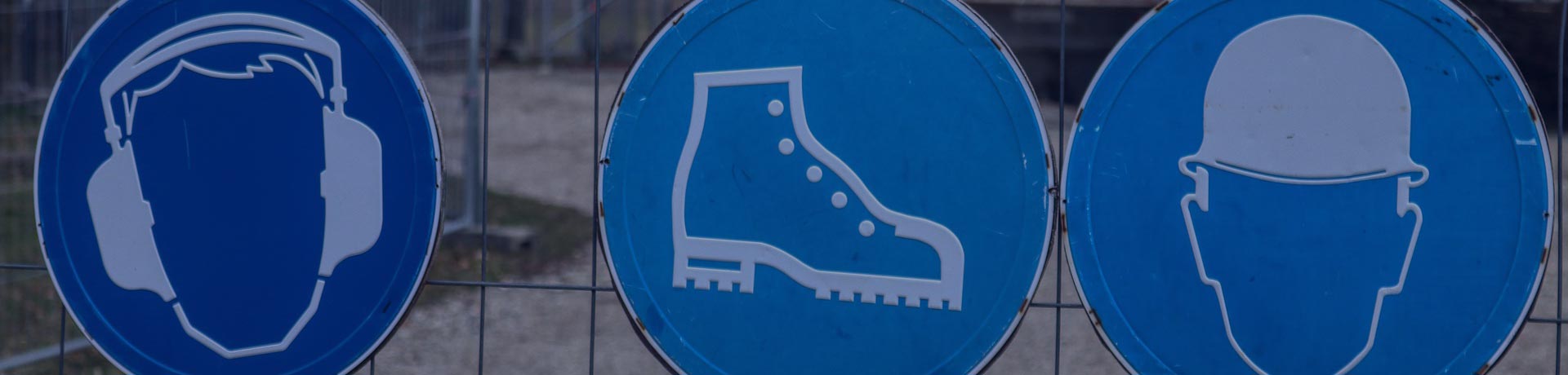 signs on a construction site indicating the main compulsory personal protective equipment