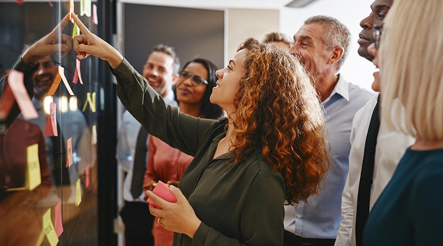 a group of people pasting postits on a board