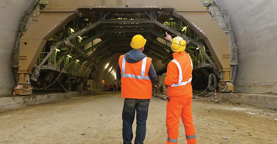 Two men in front of a tunnel construction
