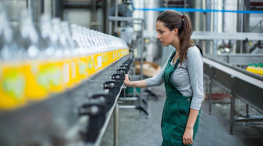 A woman in an apron controlling a production line