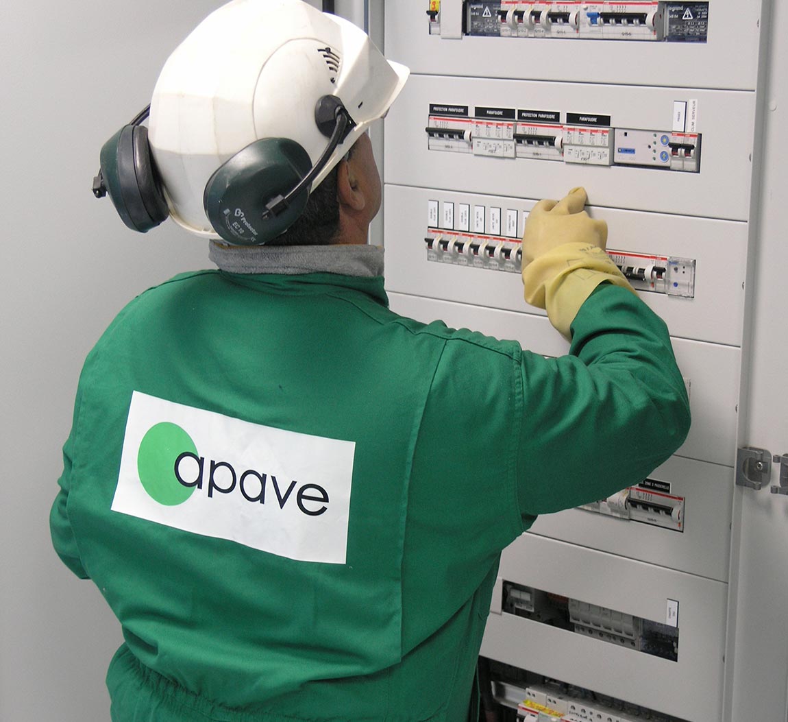 Ispezione elettrica da parte di un dipendente Apave davanti a un pannello elettrico